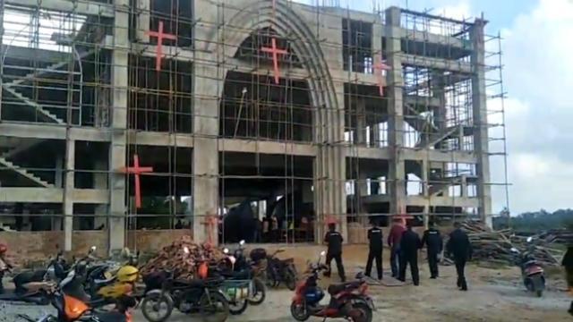 El personal que participa en la demolición forzada ingresa a la iglesia.