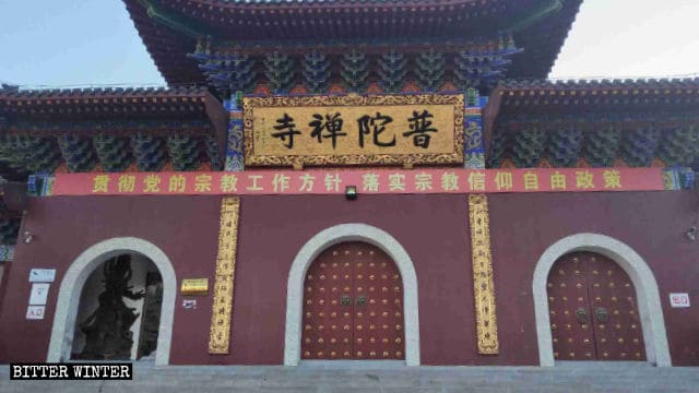 Un irónico slogan propagandístico del PCCh cuelga frente al templo de Putuo