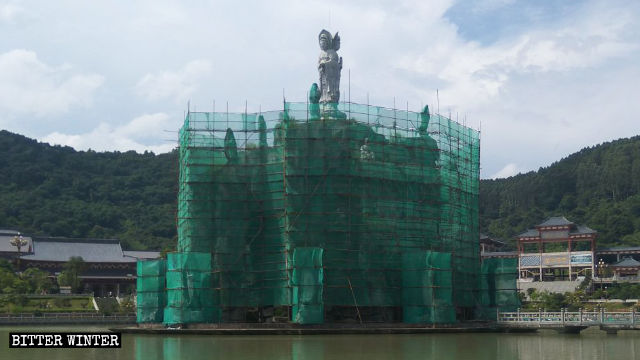 La Isla de Guanyin está envuelta en una red de seguridad de color verde.