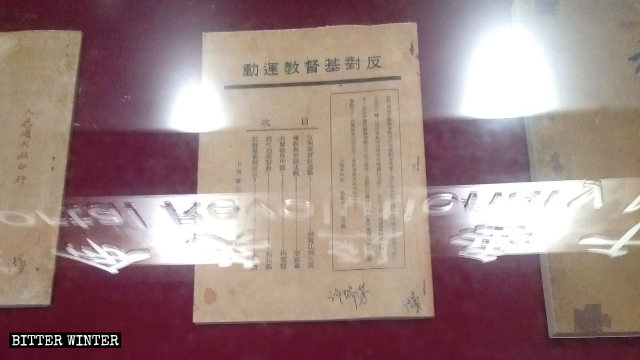 Documentos anticristianos exhibidos en una sala ancestral.