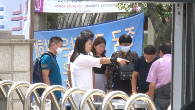 Durante una manifestación llevada a cabo fuera de las instalaciones de la IDT en Seúl, la Sra. O Myung-ok les da instrucciones a los familiares.