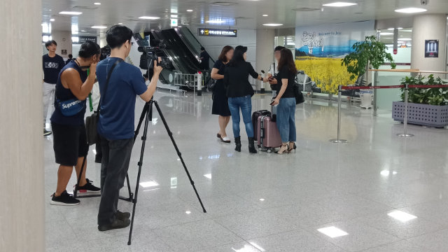 La Sra. O Myung-ok recoge a familiares de creyentes de la IDT procedentes de China continental en el aeropuerto y organiza una sesión de fotos para los medios de comunicación.