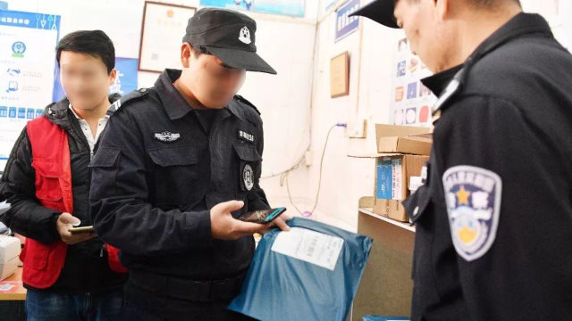 Oficiales de policía están examinando paquetes utilizando una aplicación móvil.