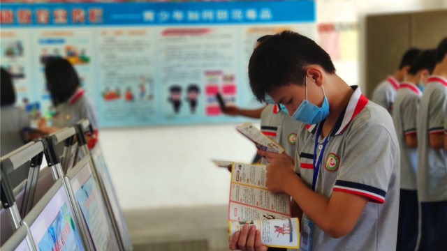 Un estudiante lee materiales anti xie jiao en el campus de una escuela emplazado en la ciudad de Enping de Cantón, en el mes de junio.