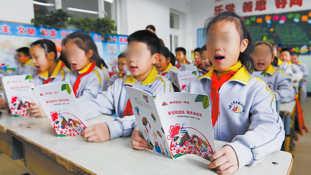 Estudiantes de una escuela primaria emplazada en Ürümqi, la capital de Sinkiang, están leyendo rimas infantiles en chino.