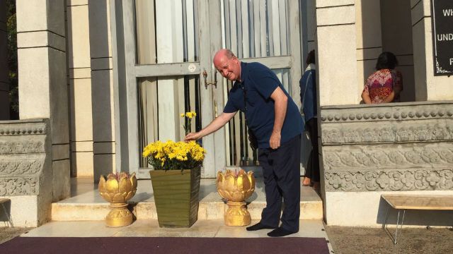 El jefe de redacción de Bitter Winter, Massimo Introvigne, colocando flores en la estupa emplazada en los campos de exterminio de Choeung Ek