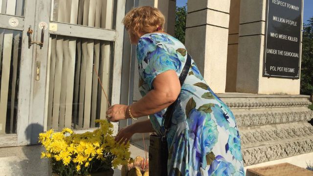 La redactores adjuntos de Bitter Winter, Rosita Šorytė, colocando flores e incienso en la estupa emplazada en los campos de exterminio de Choeung Ek.