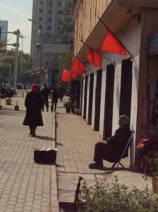 Disfrutando a la sombra de la bandera roja china en Urumchi