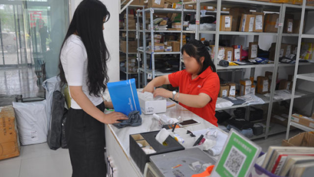 Empleados de una empresa de reparto están abriendo paquetes para inspeccionarlos.