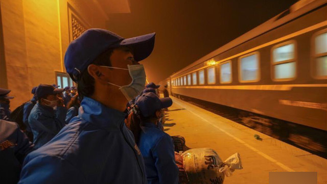 Trabajadores en una estación de ferrocarril emplazada en el condado de Moyu de Jotán en marzo, camino al norte de Sinkiang.