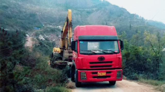 Una excavadora está subiendo una colina para demoler el templo.